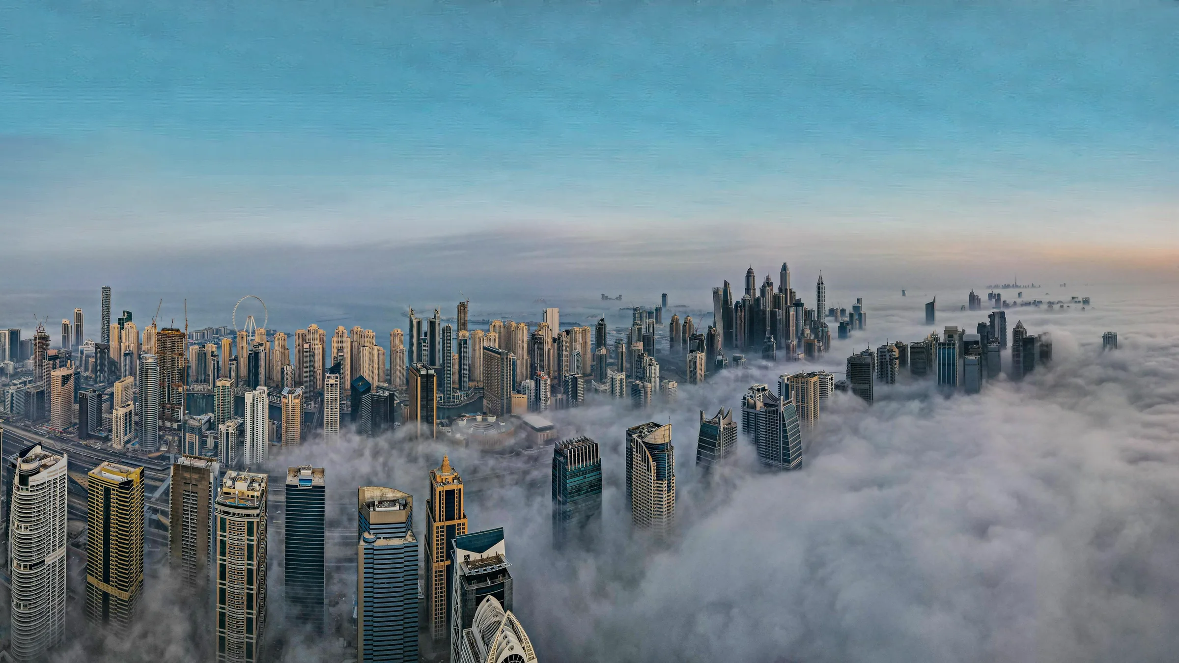 Dubai Marina rising above a sea of low cloud at first light
