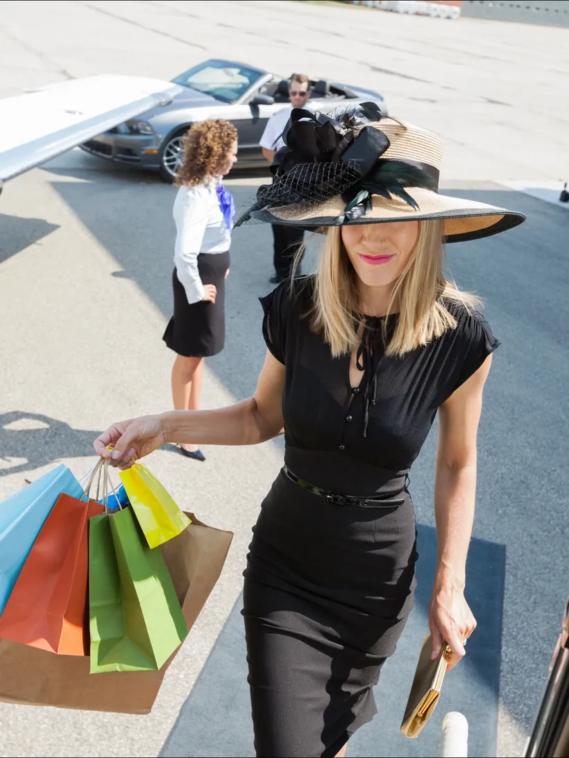 A guest walking from a private aircraft with shopping bags