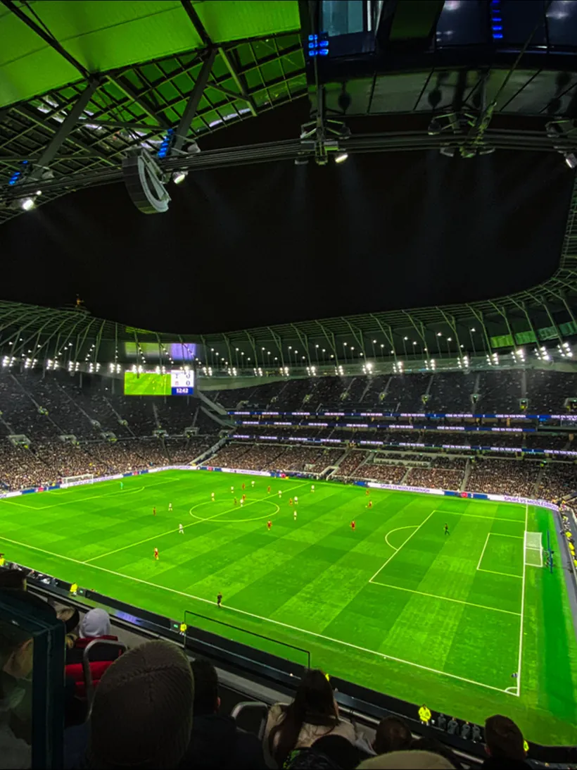 A floodlit football stadium seen from the upper tier