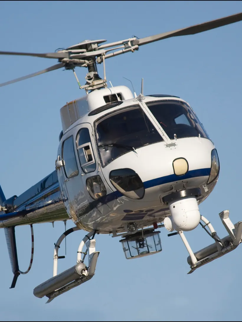 A light helicopter on approach against a clear sky